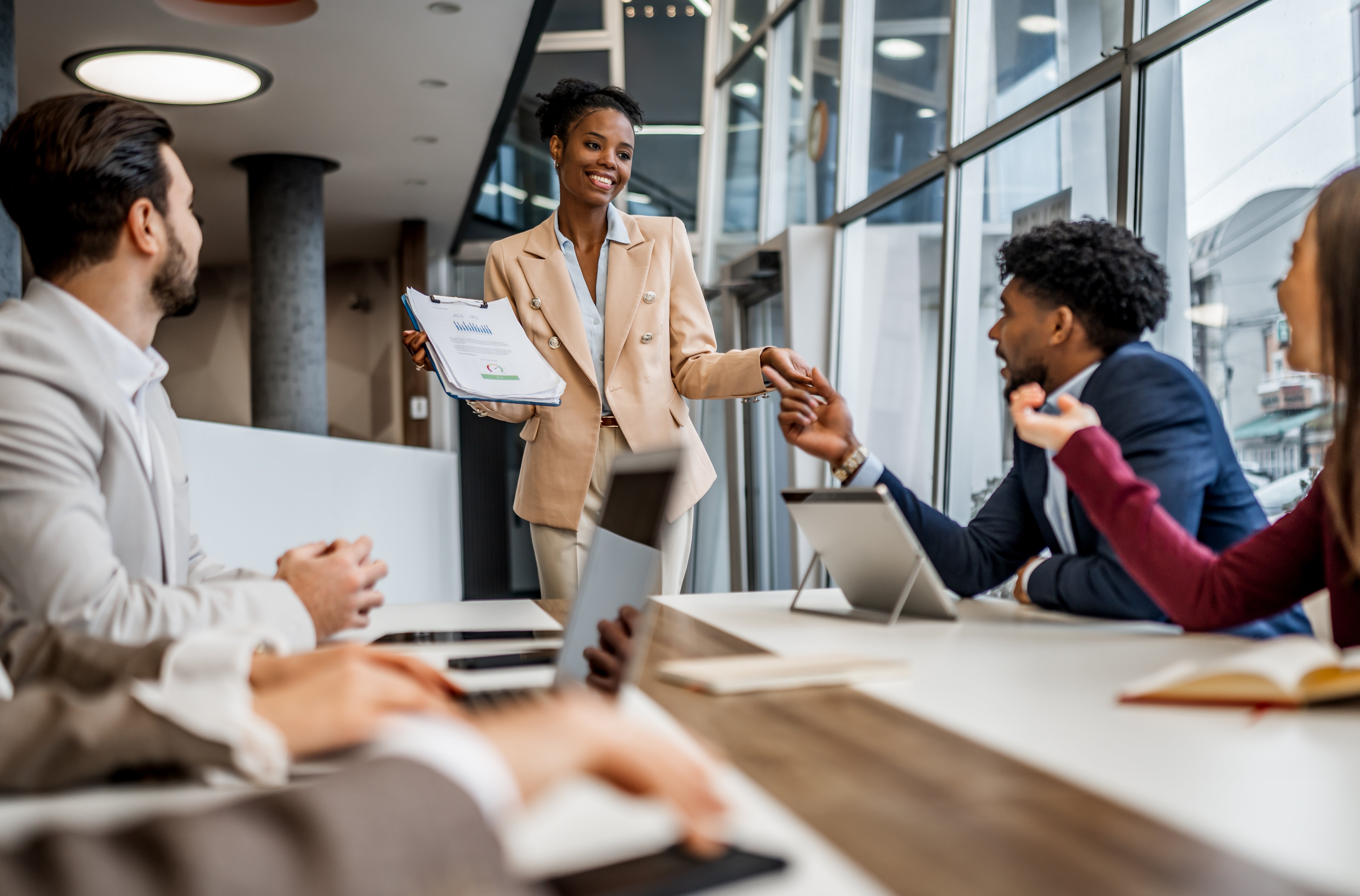 Businesswoman presenting report to diverse colleagues in meeting